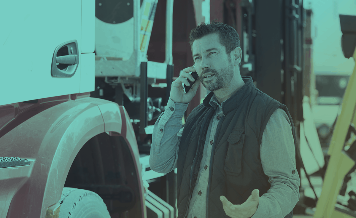 picture of a man making a phone call beside a parked trailer