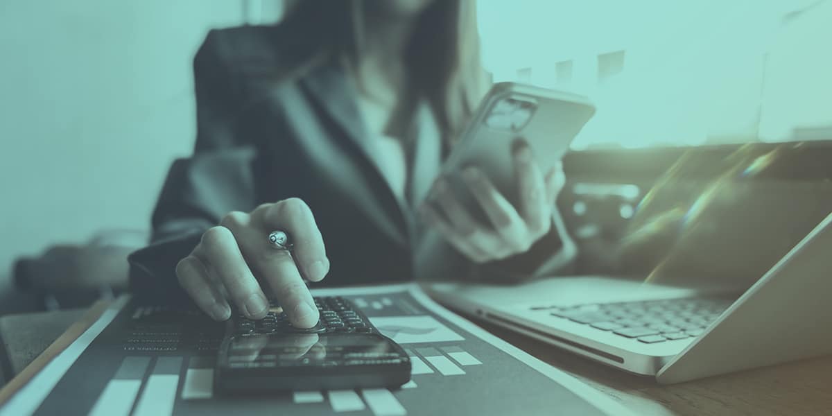 Woman Calculating her Debt on Phone Laptop and Calculator