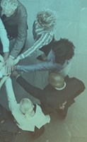 business people all with hands together in a circle