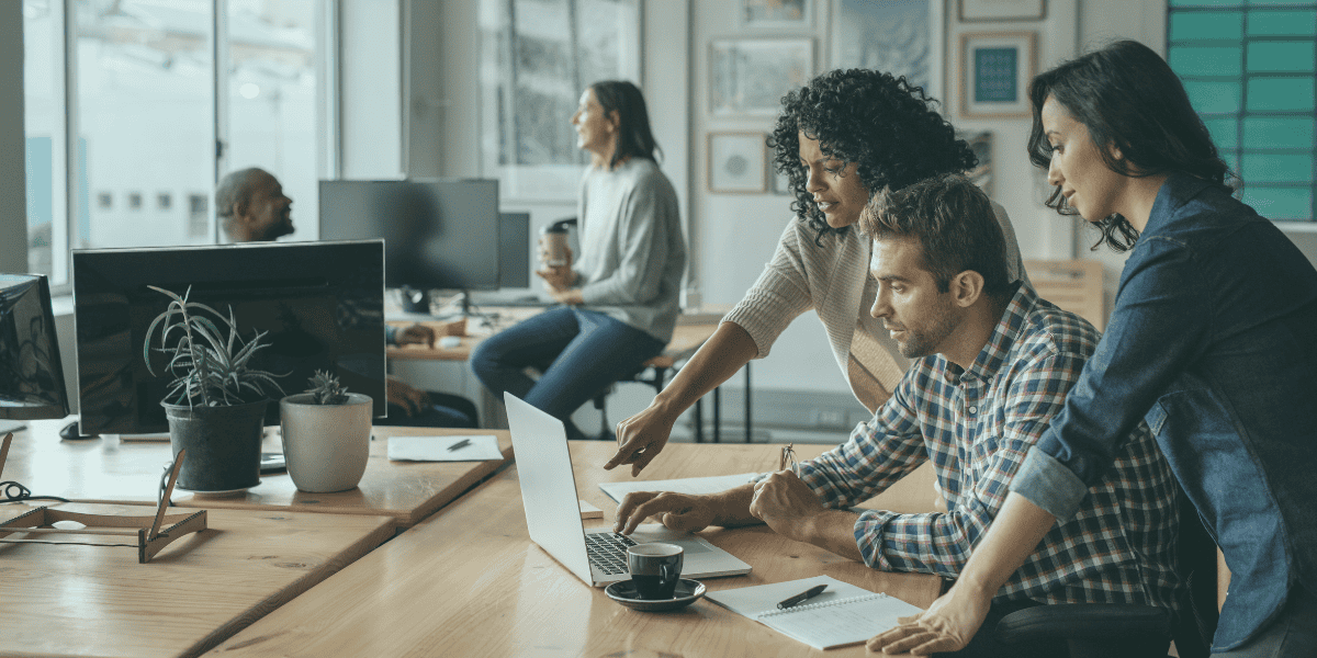 A group of business owners reviewing micro loan options on a laptop