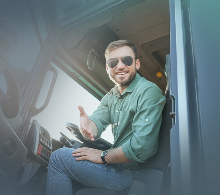 Owner-operator sitting in his truck, reaching his hand out for a hand shake.