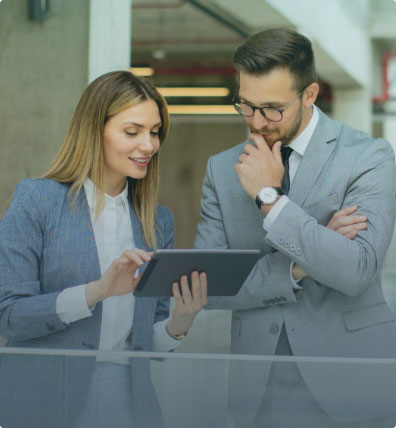 Two recruitment professionals reviewing payroll funding on a tablet.