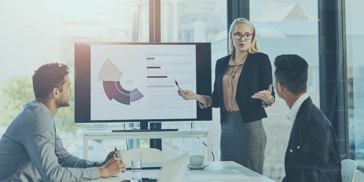 Meeting in an office setting with a dashboard of financials on a screen displaying credit availability constraints.