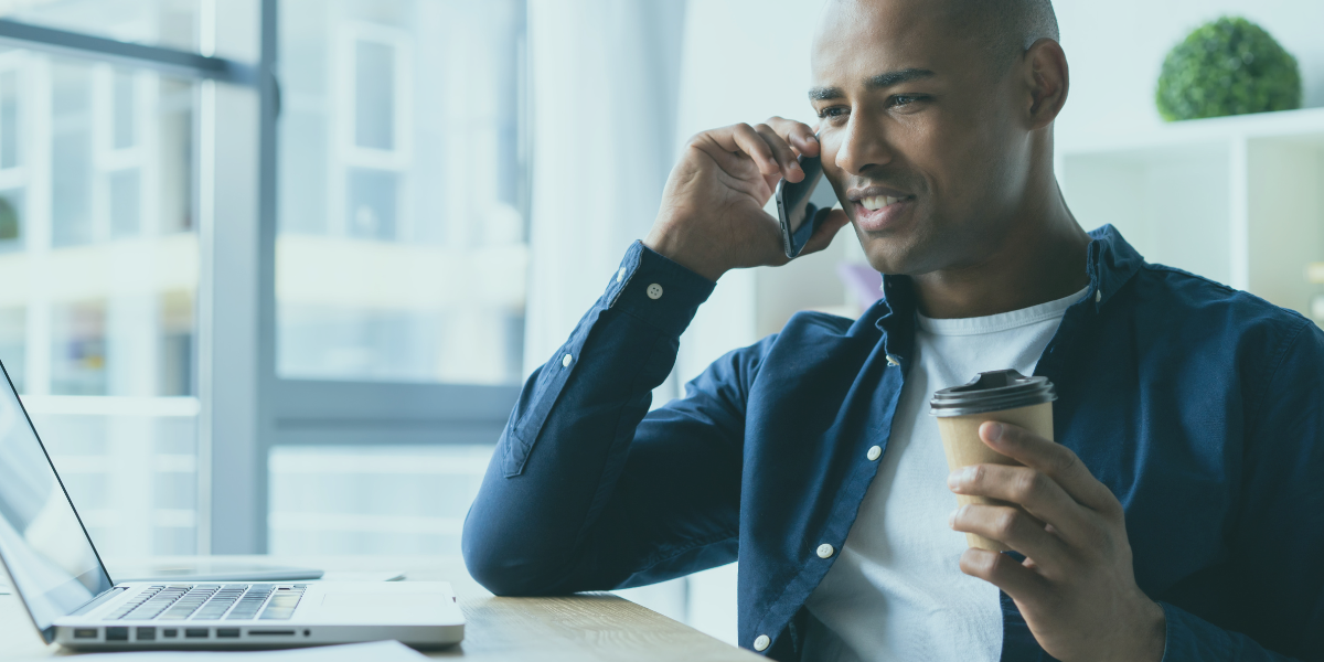 A businessman on the phone while at his computer discussing bad debt protection with a specialty lender.