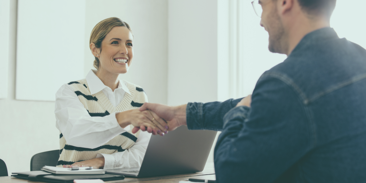Recruitment agent shaking hands with a new employee.