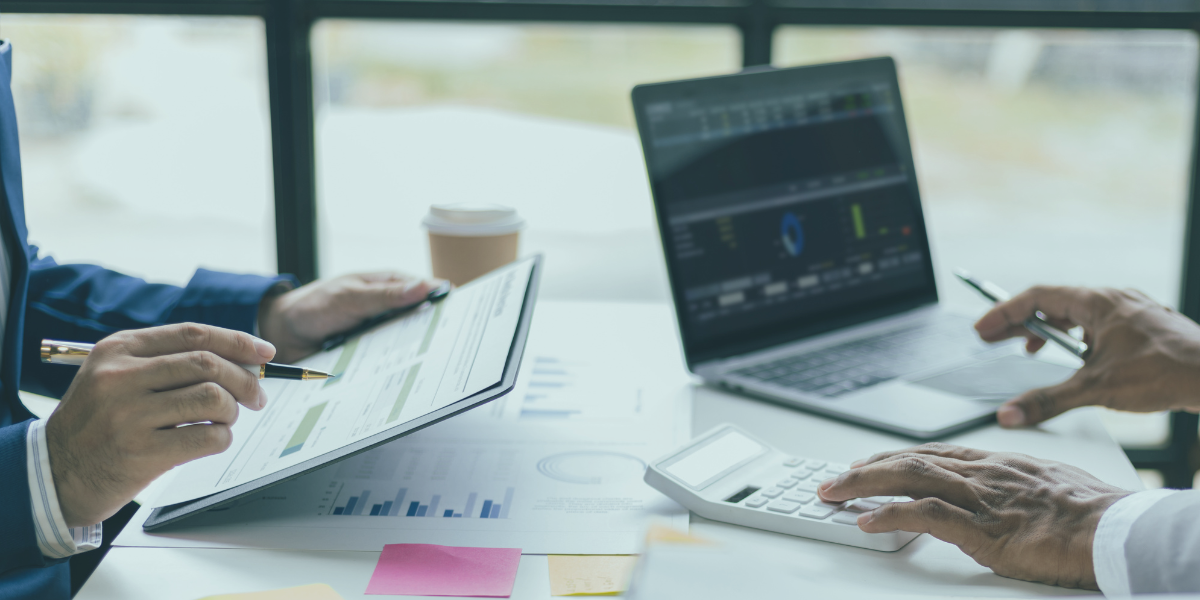 A business meeting with a laptop and notepad open.