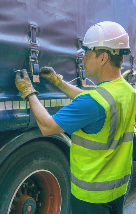 Trucker strapping up a load.