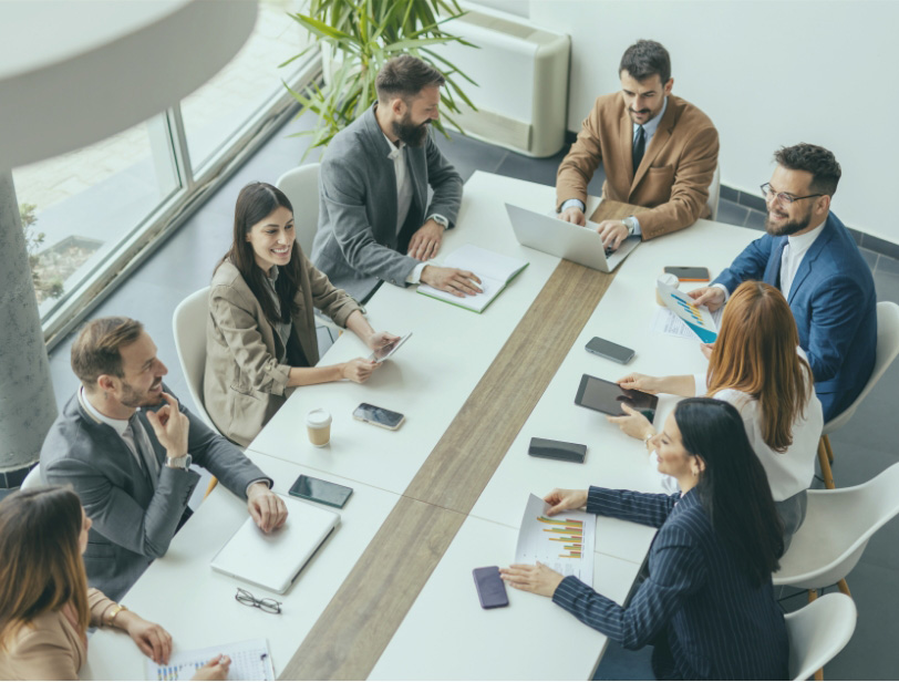Boardroom meeting full of financing professionals.