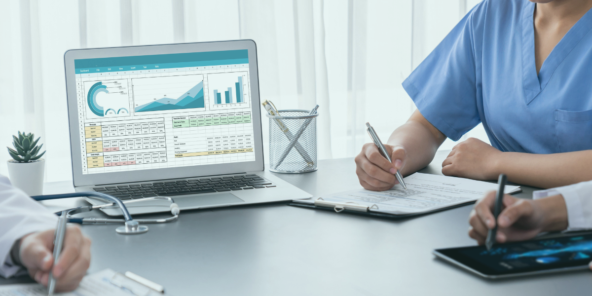 Healthcare professionals having a meeting and reviewing financials on a laptop.