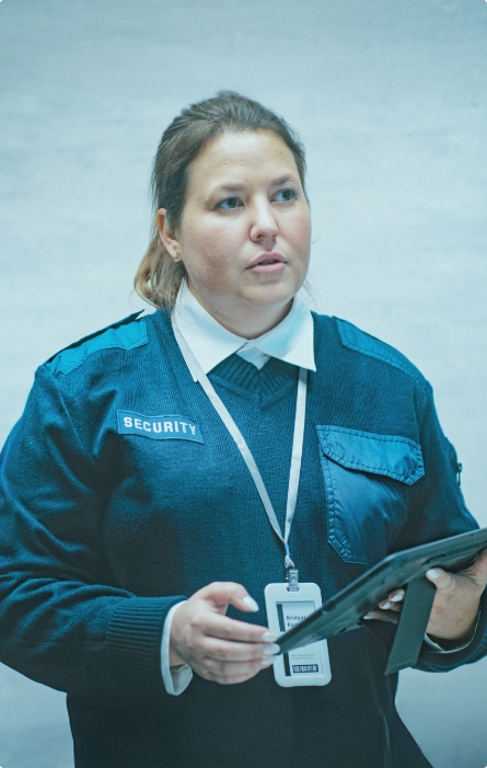 Security officer looking concerned with a tablet in her hands.