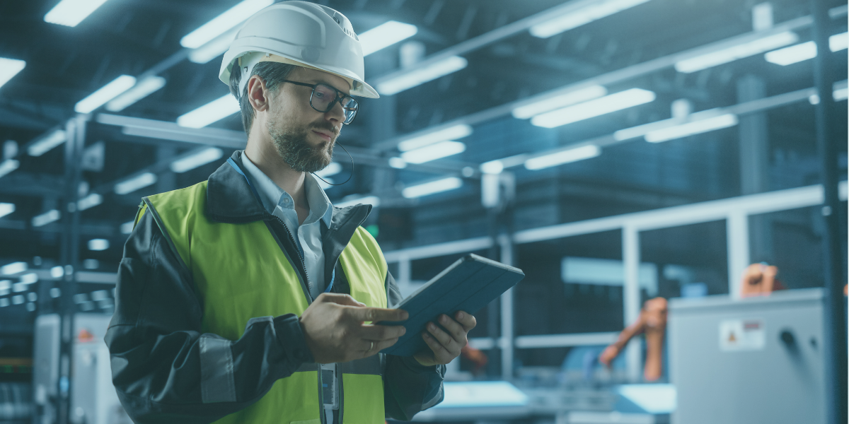 Manufacturing professional using a tablet to monitor operations and supply chain performance